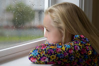 Shot for stock photography. A young girl looks out a rainy window wishing that she could go outside to play.Click to enlarge photo